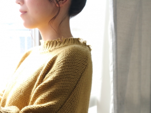 窓辺で外を眺める女性の写真