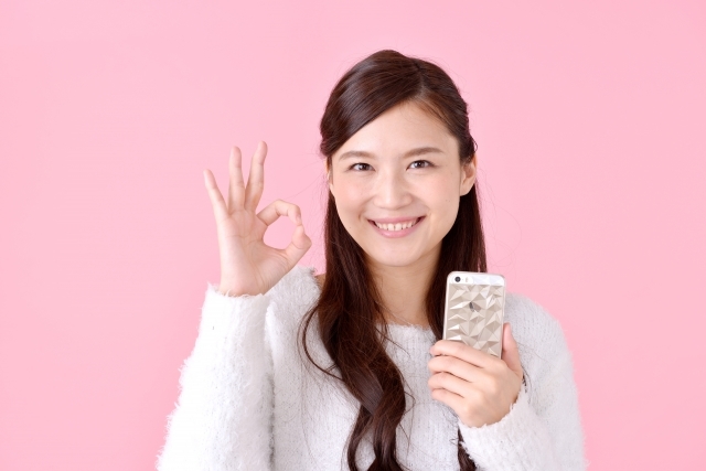 スマホでメールを受けている女性の画像